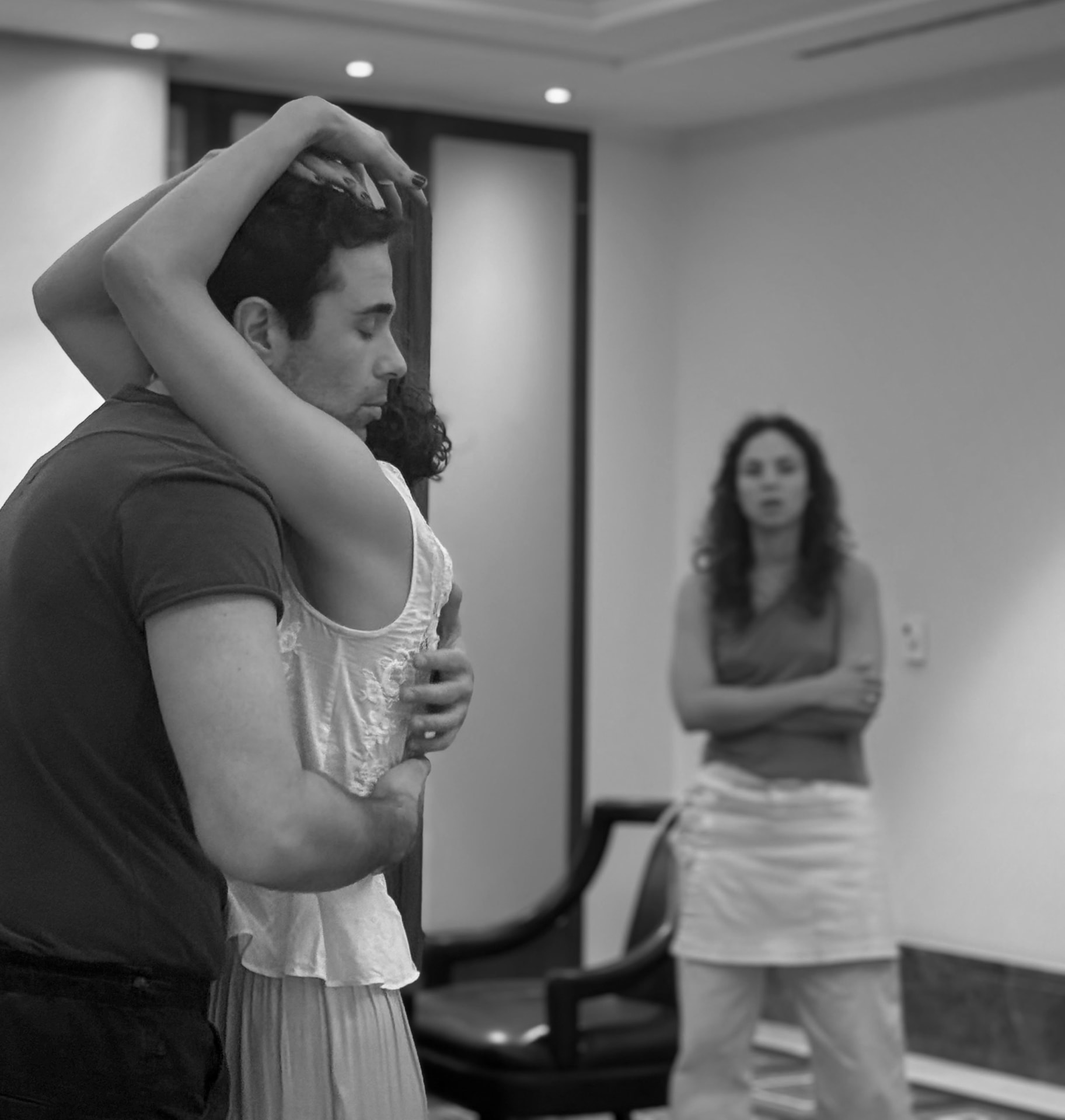 ANNA K. rehearsal — two actors in a close embrace while the director watches, black and white