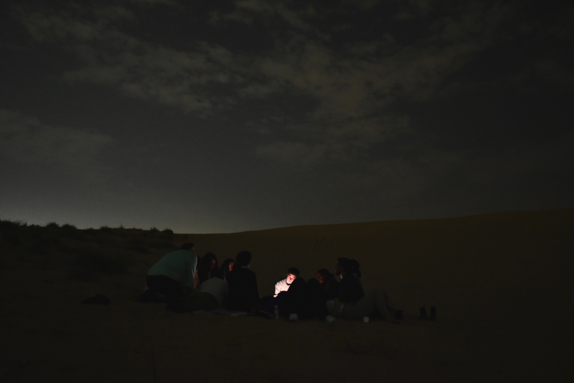 Social Dreaming Matrix workshop — a group gathered around a soft light in the desert at night